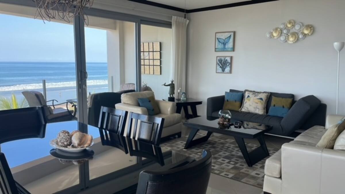 Spacious living room with sofas and a direct view of Jaco Beach